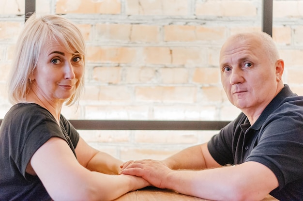 um homem e sua esposa em camisetas escuras e calças cinza