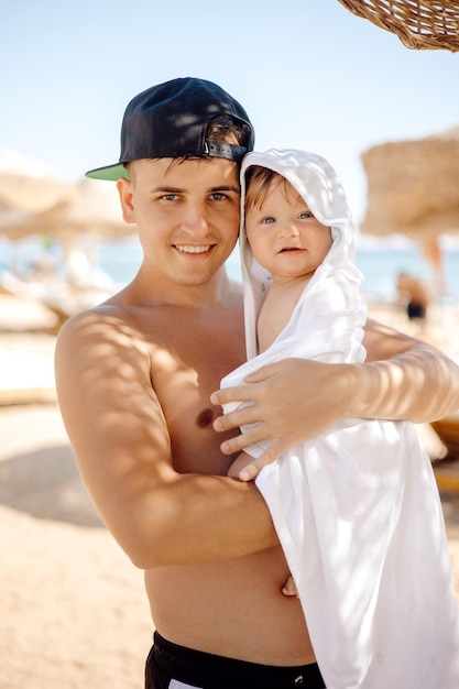 Um homem e um bebê estão na praia.