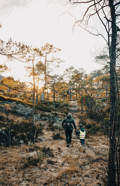 Um homem e uma criança caminhando na floresta