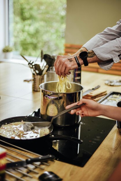 Um homem e uma mulher cozinhando em um fogão.