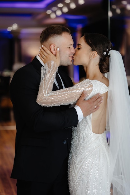 Um homem e uma mulher estão a beijar-se em frente a uma janela.