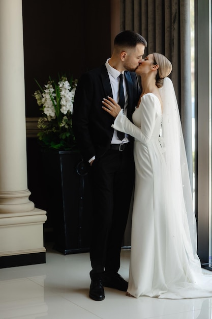 Um homem e uma mulher estão a beijar-se num edifício com flores.