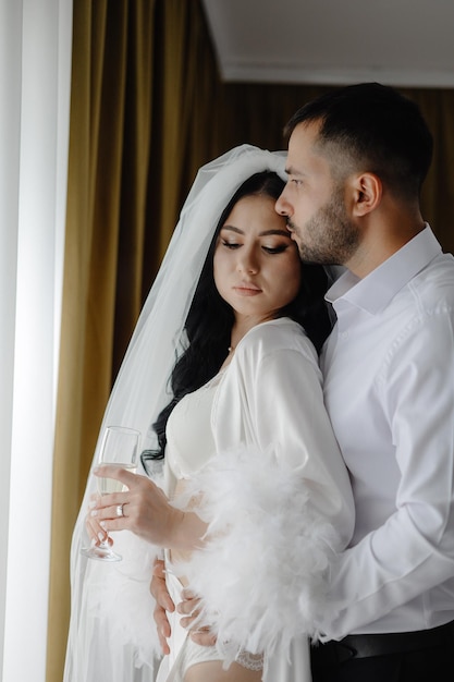 um homem e uma mulher estão olhando um para o outro e a mulher está usando um véu branco