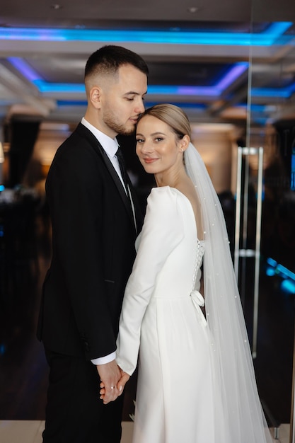 um homem e uma mulher estão posando para uma foto na frente de uma janela