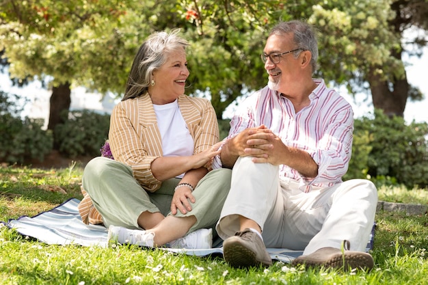 Um homem e uma mulher europeus sorridentes sentam-se em quadrinhos desfrutam de um encontro romântico um piquenique no parque divertem-se