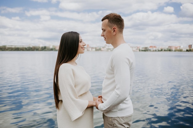 Um homem e uma mulher grávida perto do lago