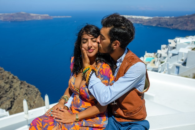 Um homem e uma mulher se beijam contra a rocha Skaros, na ilha de Santorini. A aldeia de Imerovigli.Ele é um cigano étnico. Ela é israelense.