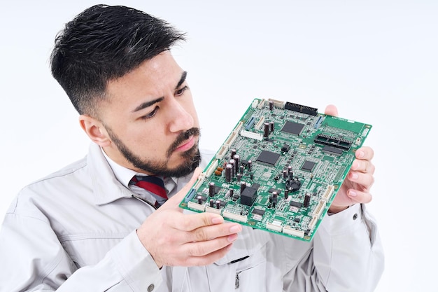 Um homem em roupas de trabalho com uma placa de computador