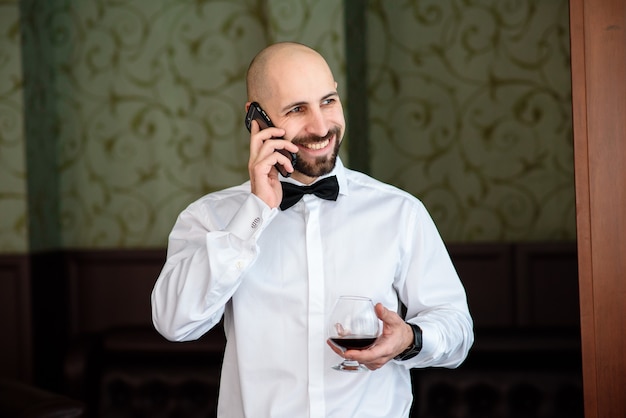 Um homem em um restaurante falando ao telefone.