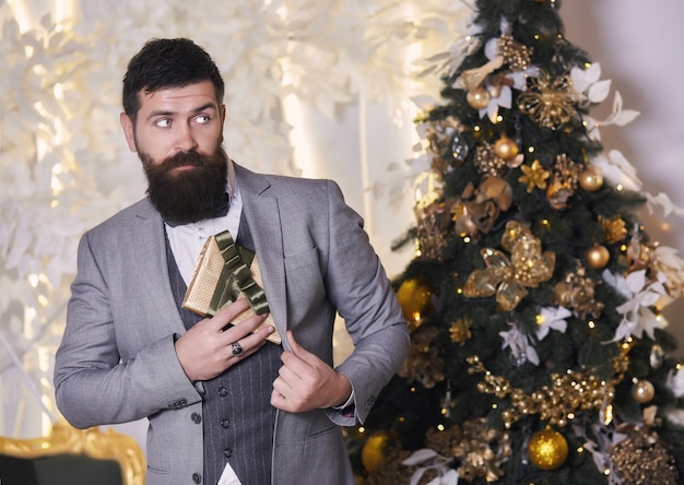 Um homem em um terno elegante esconde um presente escondido sob sua jaqueta