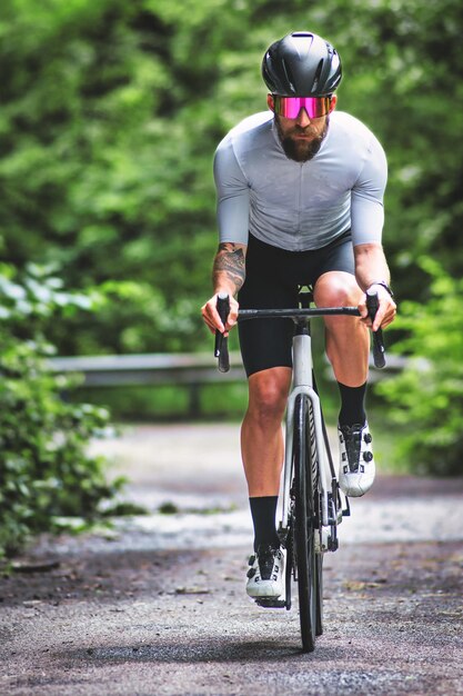 Foto um homem em uma bicicleta de corrida em uma estrada estreita