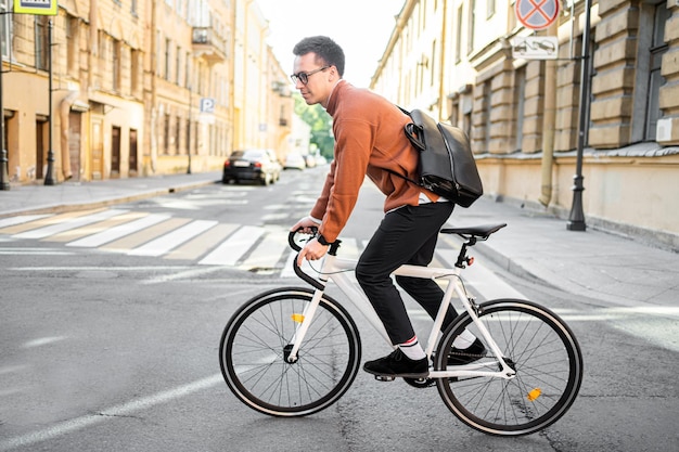 Um homem em uma bicicleta de negócios vai trabalhar no transporte ecológico urbano