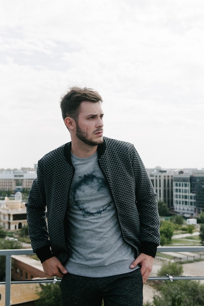 Um homem em uma blusa cinza com um zíper posando.