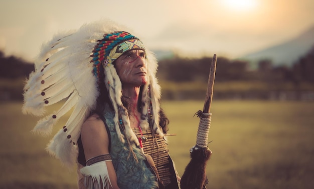 um homem em uma roupa tradicional indiana está em um campo