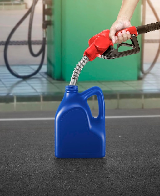 Um homem enche jerry cans em um posto de gasolina