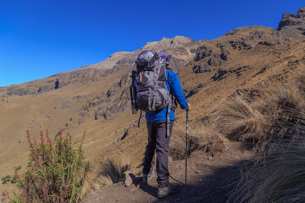 Um homem escalando uma colina nas montanhas do vulcão iztaccihuatl