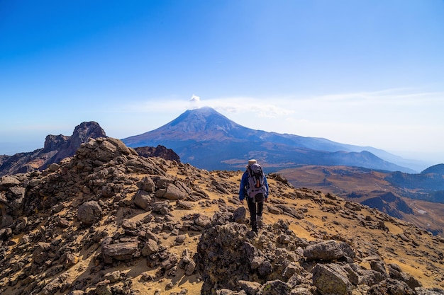 Um homem escalando uma colina nas montanhas do vulcão iztaccihuatl