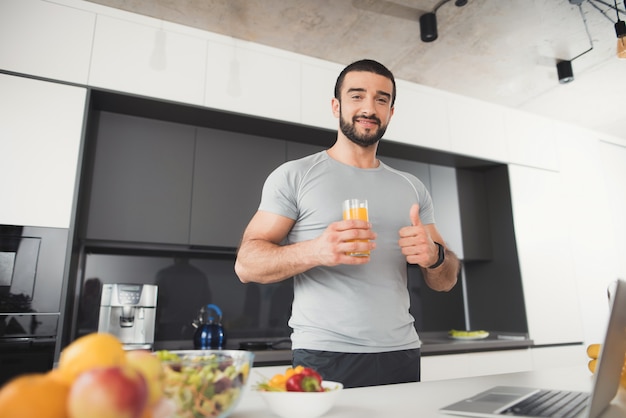 Um homem esportivo está posando na cozinha.