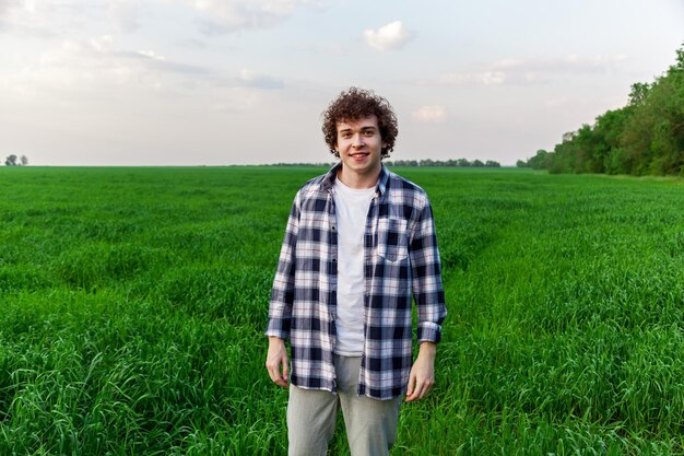 Um homem está de pé na grama verde em um campo