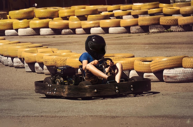 Um homem está dirigindo Gokart com velocidade no parque na vista frontal da pista de karting