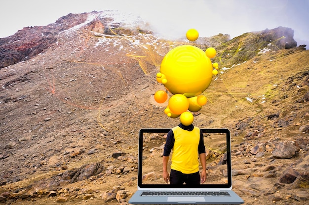 Um homem está em frente a um computador com uma bola amarela.