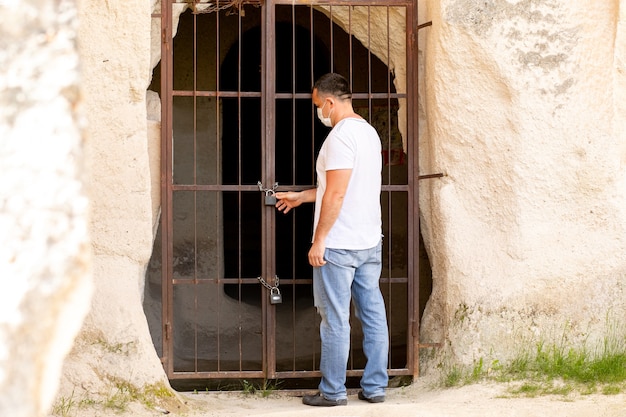 Um homem está em frente a uma porta de metal fechada com uma limitação de bloqueio de cadeado devido ao coronavírus