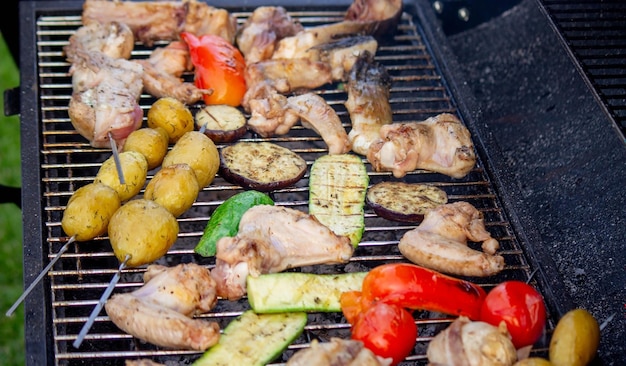 Um homem está grelhando legumes e carne Foco seletivo Natureza