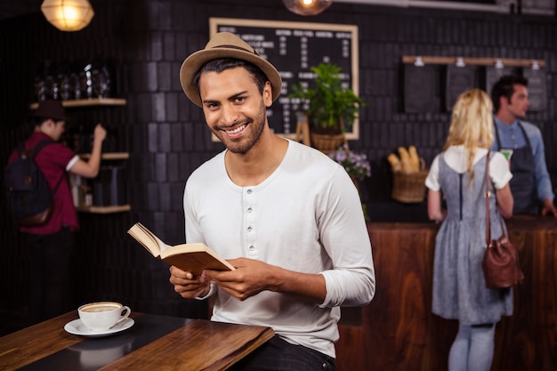 Um homem está lendo um livro e sorrindo