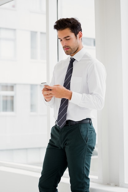 Um homem está segurando seu smartphone e mensagens de texto