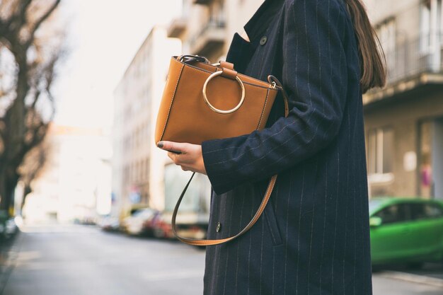 Foto um homem está segurando uma bolsa marrom com um grande círculo redondo na frente