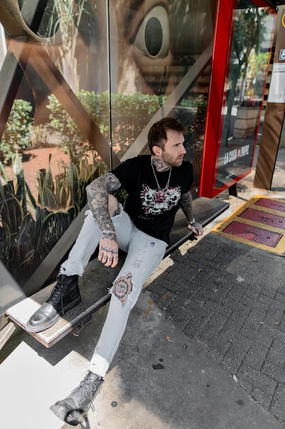 Foto um homem está sentado em um banco em frente a uma porta de vidro.