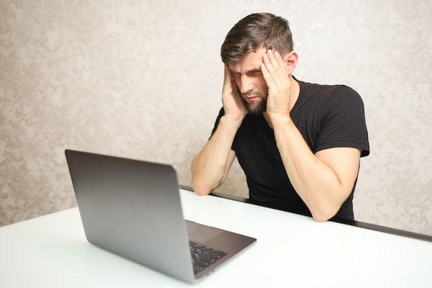 um homem está sentado em um laptop