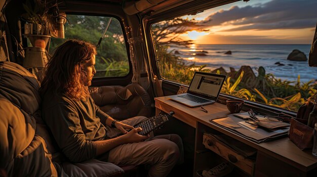 Foto um homem está sentado em uma van com um laptop no colo e um pôr do sol ao fundo.