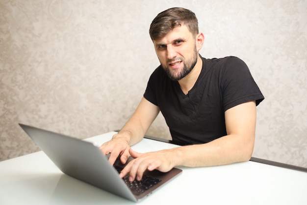 um homem está sentado na frente de um laptop