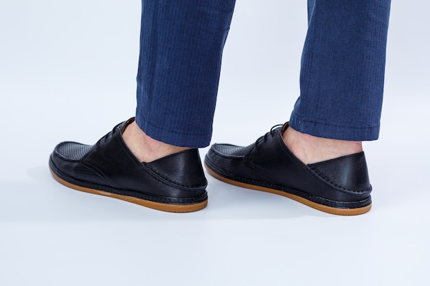 Um homem está usando sapatos pretos clássicos feitos de couro natural com renda, sapatos masculinos no estilo empresarial