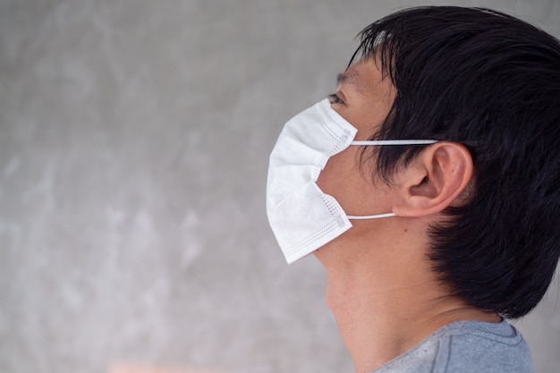 Um homem está usando uma máscara para impedir que o vírus COVID-19 se espalhe pelo mundo ou evite o uso da pm2.5. Todos devem dar as mãos para parar a infecção mortal.