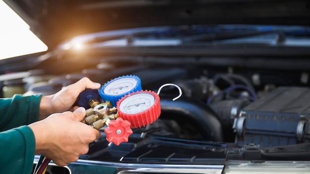 Um homem está verificando a temperatura de um carro com um manômetro.