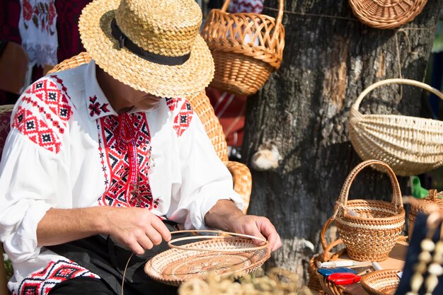 Um homem faz produtos de palhaArte popularTecendo cestos de palha Artesão