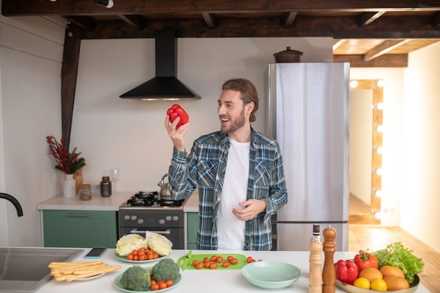 Um homem fazendo uma salada saudável em sua cozinha