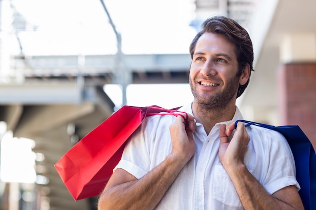 Foto um homem feliz e sorridente com sacolas de compras