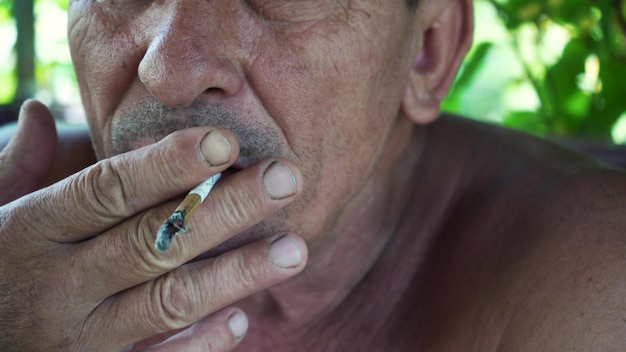 Um homem fuma um cigarro entre o trabalho Closeup Muita fumaça Fumar é prejudicial à saúde O conceito de maus hábitos
