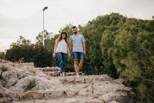 Um homem hispânico e sua garota latina estão caminhando no parque das montanhas na Espanha