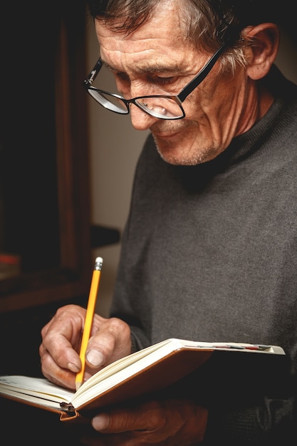 Um homem idoso escreveu a lápis em um caderno