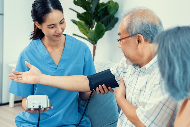 Um homem idoso tendo uma verificação de pressão arterial por seu cuidador pessoal