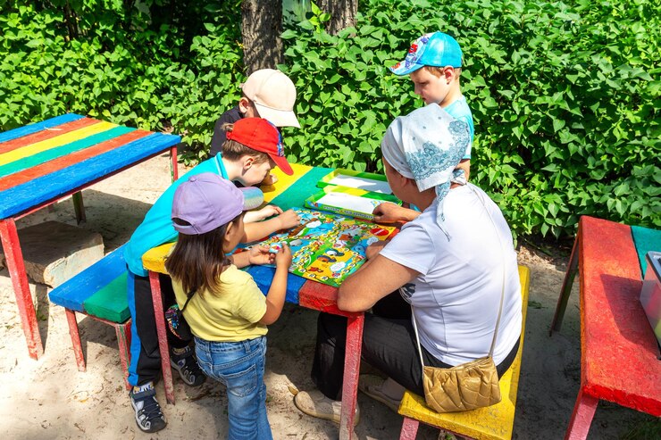 um homem jogando um jogo de tabuleiro com crianças jogando no parque