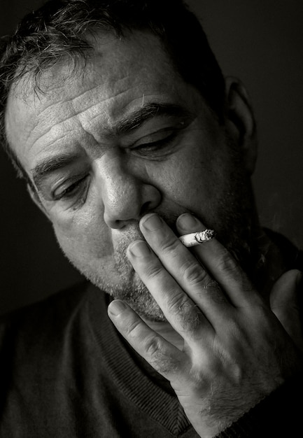 Foto um homem maduro fuma um cigarro.