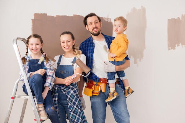 Foto um homem moreno bonito, sua linda esposa loira e seus dois filhos estão em sua nova casa