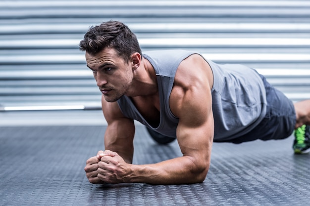 Foto um homem musculoso na posição de prancha