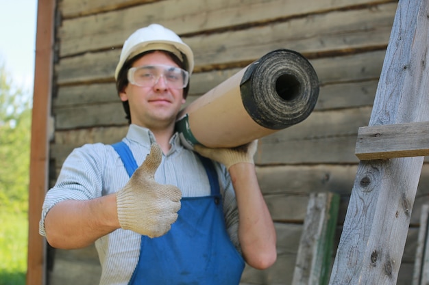 Um homem na forma de um construtor conserta uma casa