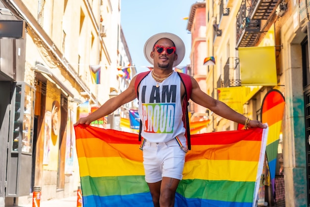 Um homem negro gay andando na festa do orgulho com uma bandeira LGBT visitando a cidade